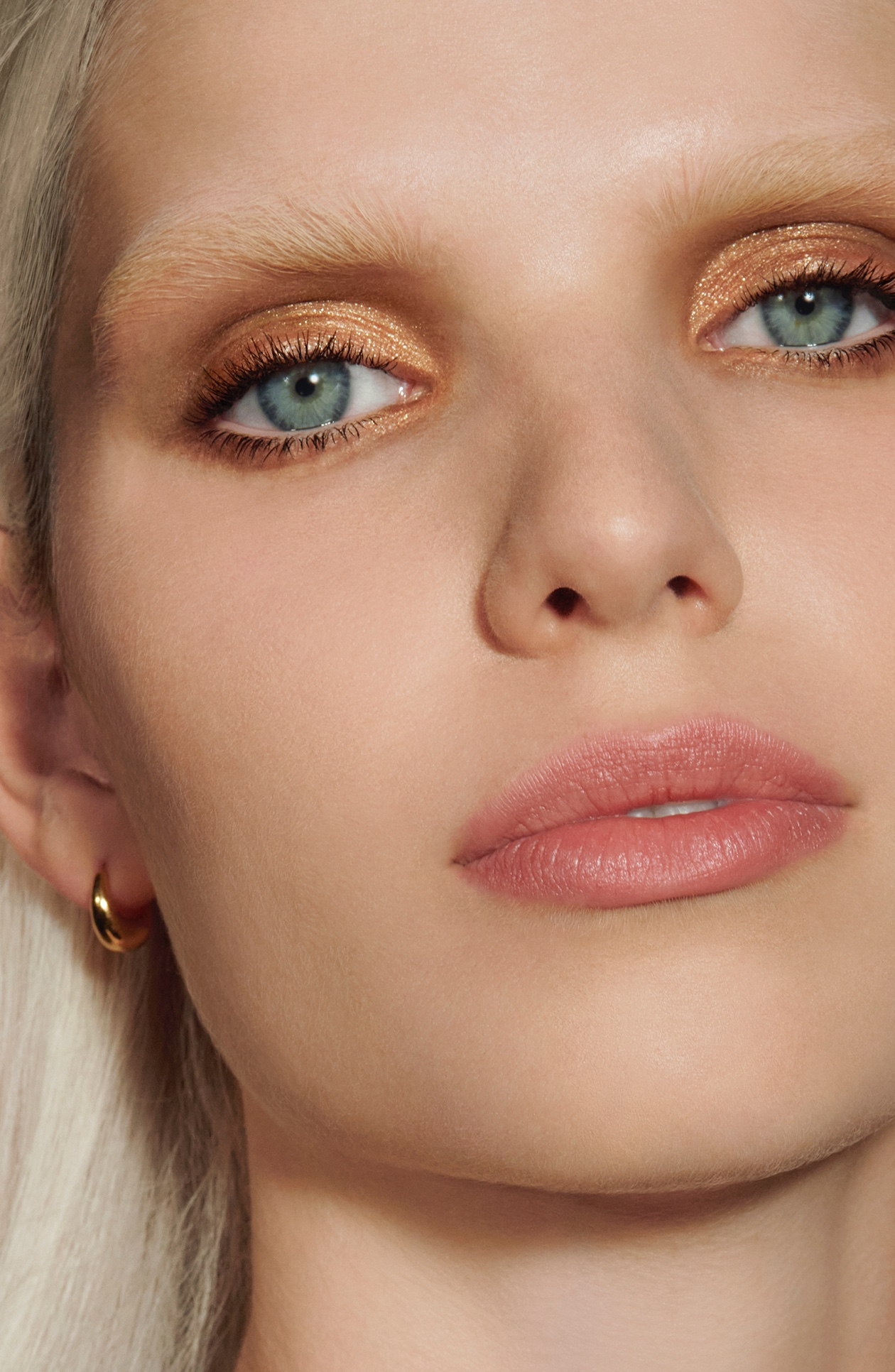 Image of a model wearing the Rose Inc Satin and Shimmer Eyeshadow Duet Palette in Copper along with the Ultra-Black Mascara.