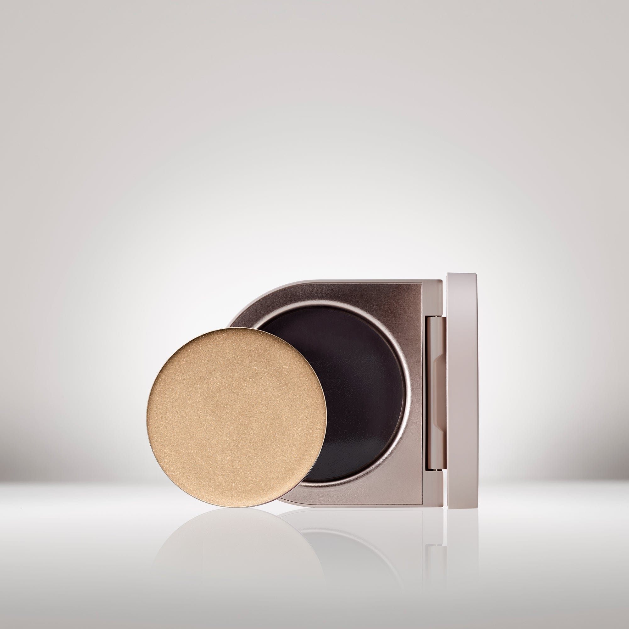 Image of the Solar Radiance Hydrating Cream Highlighter in shade Prismatic in front of the open compact